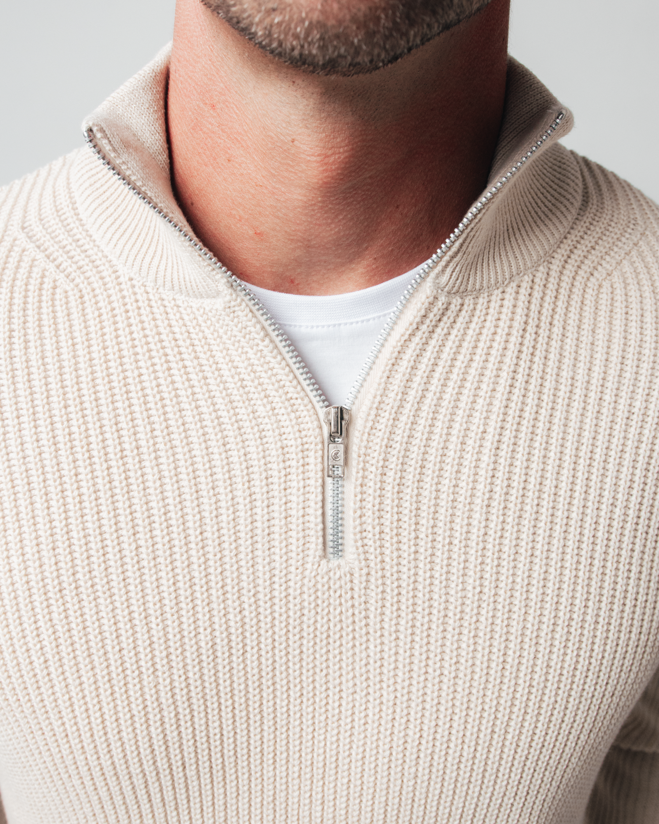 Detalhe do tricot ponto pérola — algodão cru — gola alta com zíper Parla